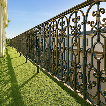 Balcon de ville aménagé en faux gazon - Rembarde en fer forgé