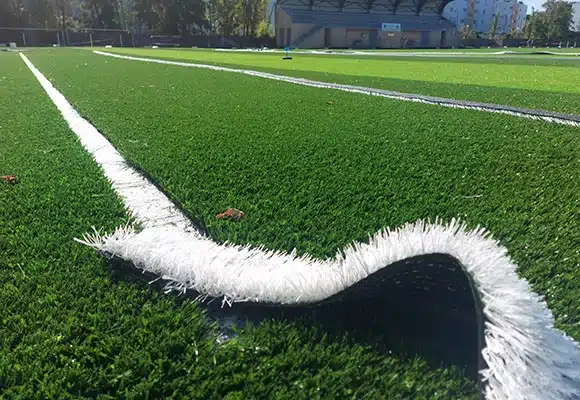 Le gazon synthétique pour le football 4 Pose de fausse pelouse - bande blanche