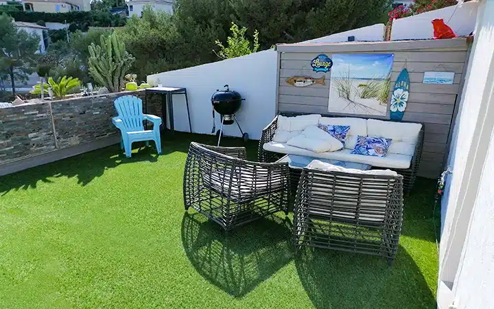 Mobilier de jardin et gazon synthétique : un duo gagnant 1 Exemple d'un salon de jardin sur une terrasse avec une pelouse artificielle